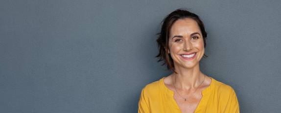 Frau in gelbem Shirt lächelt zufrieden