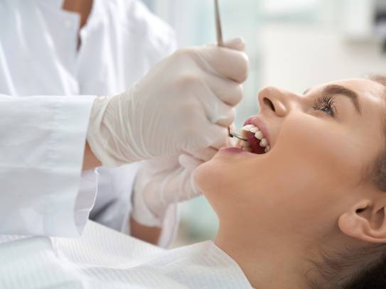 Zahnarzt macht einen Prophylaxe-Check bei einer Patientin